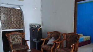 A living room with wooden furniture, a patterned rug, and a blue wall.
