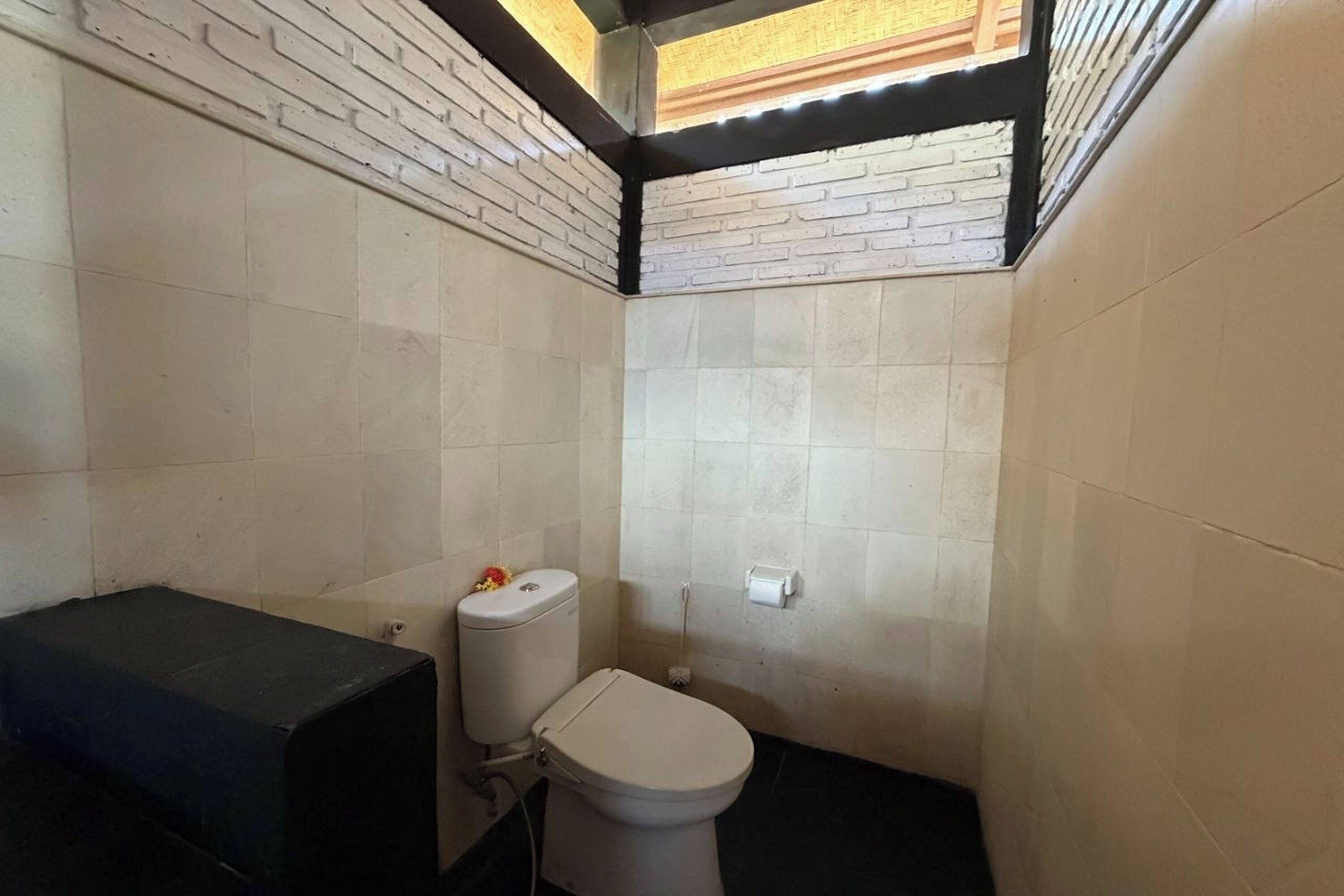 Un baño pequeño con azulejos, que incluye inodoro, lavabo y zona de ducha.