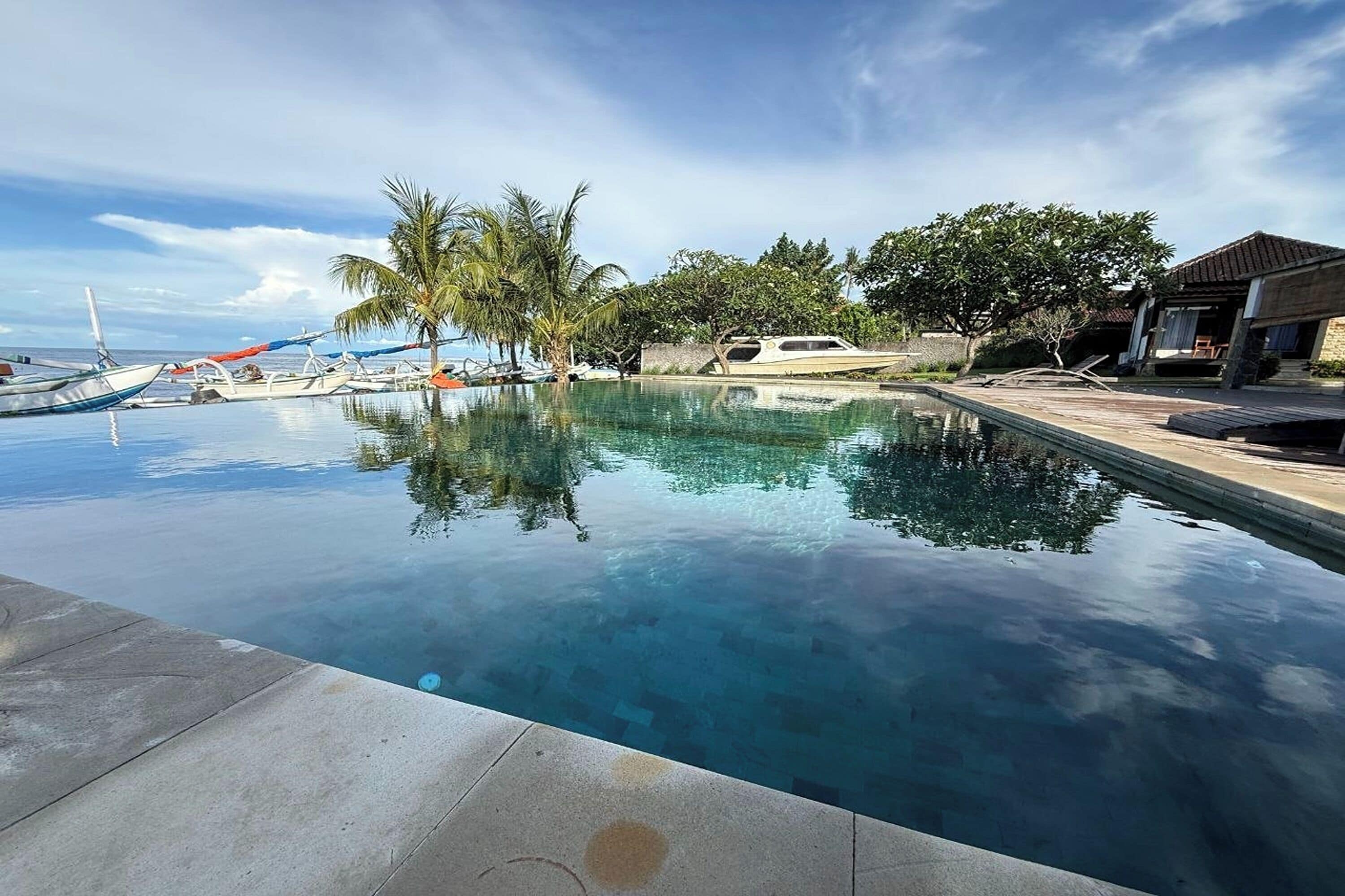 Una piscina al aire libre, sillones reclinables de piscina