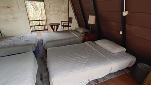 A room with three beds arranged in a row, a small round table with chairs, a lamp, and a broom. - Seribu Batu Songgo Langit Resort & Camp (Mangunan)