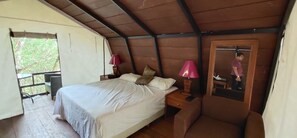 Une chambre à coucher avec un lit, des lampes de chevet, une chaise et une fenêtre.