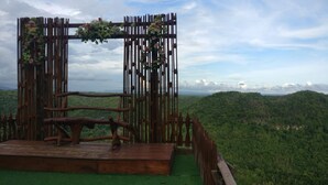 A wooden stage with a bench and a decorative archway with flowers. - Watu Mabur Holiday Centre and Camping (Mangunan)