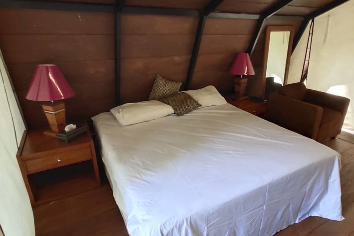 Une chambre à coucher avec un lit, deux lampes de chevet, une table de chevet et une tête de lit en bois.
