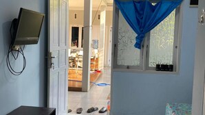 Une chambre équipée d’un lit, d’un bureau, d’une télévision et d’un climatiseur.
