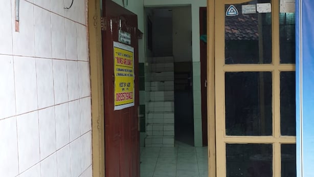 A doorway leading to a tiled hallway with a sign indicating a room for rent. - Homestay Mas Arjuna - Female Only (Surabaya)