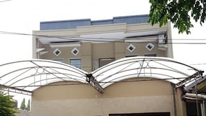 A two-story building with a garage and a gated entrance. - Kost Harian 86 (Surabaya)