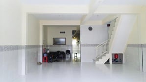 A spacious, modern interior with a staircase leading to an upper level. - Kost Harian 86 (Surabaya)