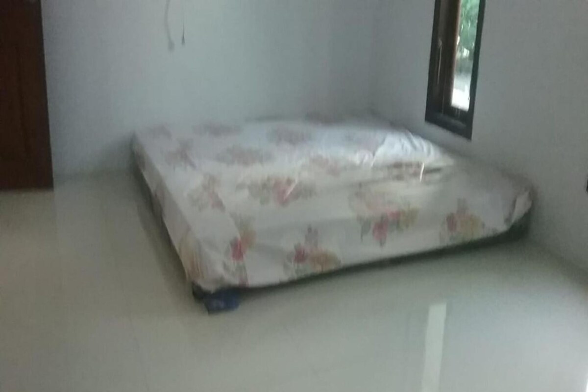 A room with a bed, a window, and a door.
