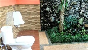 A bathroom with a toilet, bidet, and a wall-mounted towel rack. - Fida Ijen Crater Guesthouse (Banyuwangi)