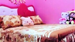 A pink-themed bedroom with a bed, pillows, and stuffed toys. - Fida Ijen Crater Guesthouse (Banyuwangi)