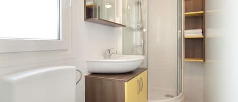 A bathroom with a toilet, sink, and shower.