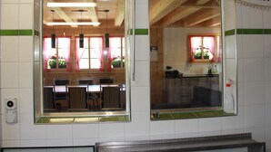 Una habitación con un ventanal grande, techo de madera y pared con azulejos.
