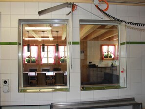 Ein Zimmer mit einem großen Fenster, einer Holzbalkendecke und einer Fliesenwand.