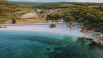 Rannalla, valkoista hiekkaa, aurinkovarjoja, rantabaari