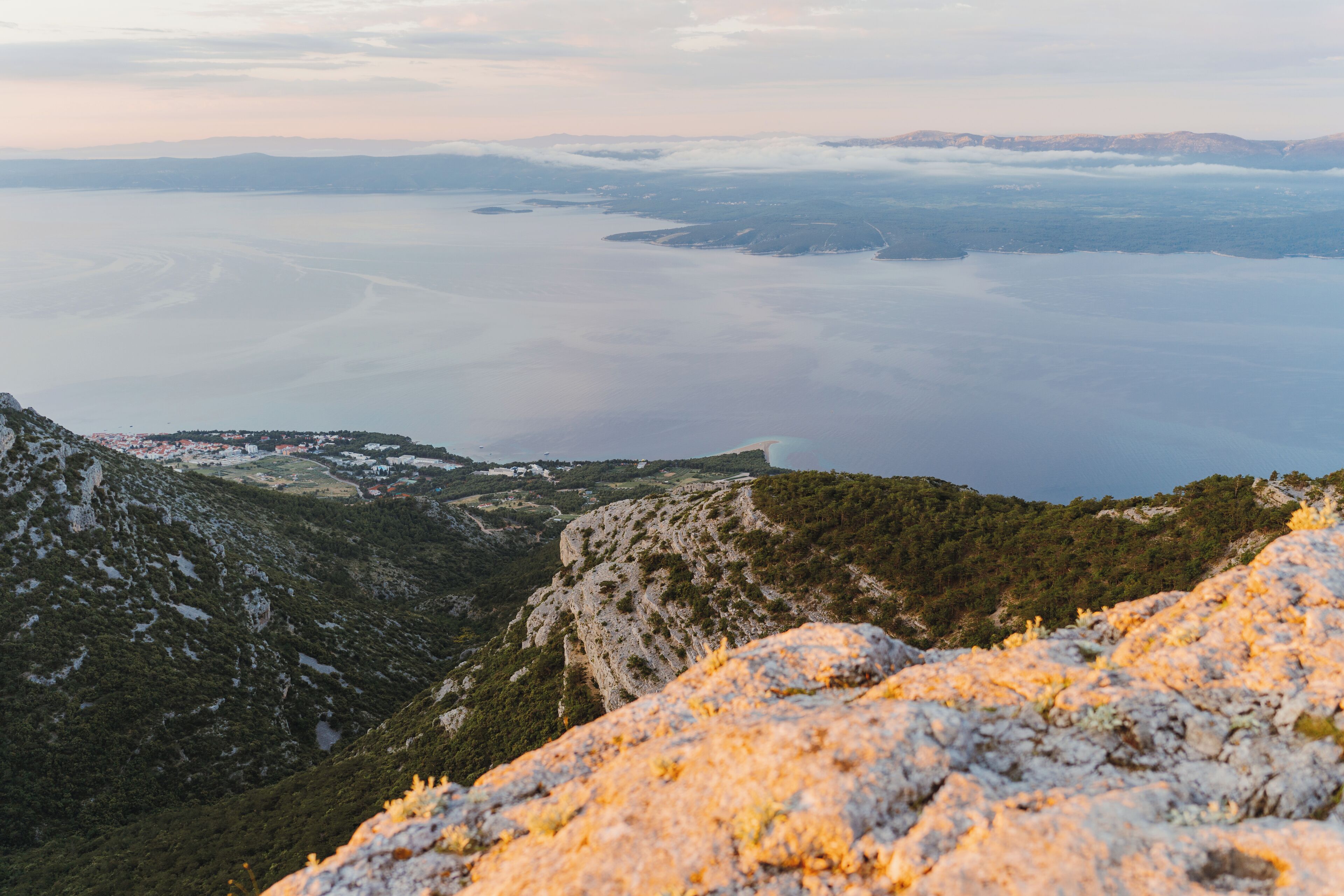 A mountainous landscape with a view of a valley and a body of water.