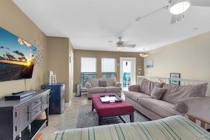 Relax in this stylish living room with a large flat-screen TV, comfortable sofas, and a cozy coffee table.