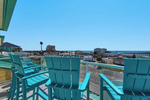 Enjoy the city view from this balcony with comfortable chairs.