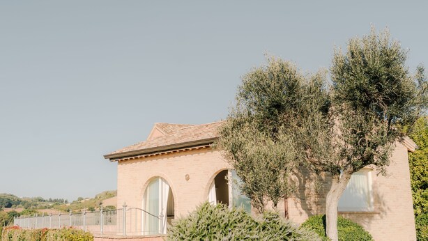 A building with a tiled roof, arched windows, and a white fence. - Rent room Nontiscordardimè (Civitanova Marche)