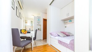 A compact room with a bed, a desk, and a chair. There is a small kitchenette in the background. - Spacious studio with balcony, close to the Znjan beach (Split)