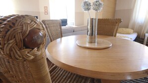 A round wooden table with a metal vase and two spherical decorations. - a-domo Apartments Oberhausen - Budget Apartments & Flats - short & longterm - single & grouptravel (Oberhausen)