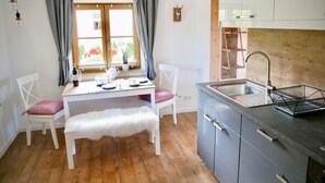 A kitchen with a wooden countertop, a sink, and a window with curtains. - Ferienwohnung bis 2 Personen, Erdgeschoss, Terrasse (Grassau)