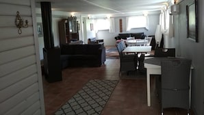 Ein großzügiger Wohnbereich mit Esstisch, Sofa und Küchenzeile.