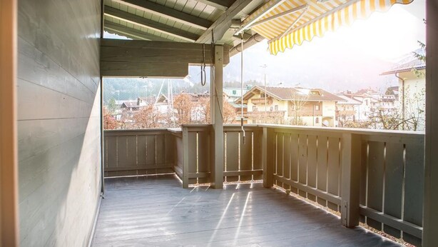 Un balcon en bois donnant sur des immeubles d’habitation.