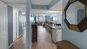 A spacious hallway with a dining area, a kitchen, and a living room. - Regency Towers 703 (Panama City Beach)