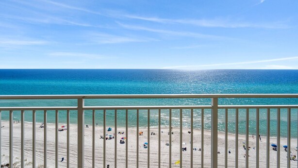 Ein Strand mit freiem Blick auf das Meer und einem Balkongeländer.