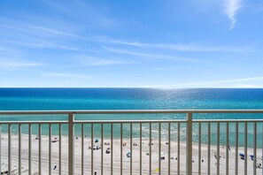 A beach with a clear view of the ocean and a balcony railing. - Emerald Beach Resort by iTrip Panama City Beach (Panama City Beach)