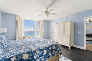 Ein Schlafzimmer mit Bett, Deckenventilator, Kleiderschrank und Meerblick.
