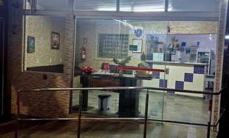Uma área de recepção com balcão, extintor de incêndio e parede revestida com azulejos.