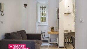 Ein kompakter Wohnraum mit Sofa, Esstisch und Stuhl, der eine ideale Arbeitsumgebung zeigt.