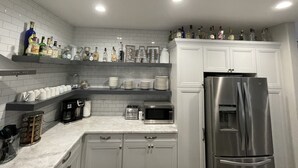A modern kitchen with white cabinets, a stainless steel refrigerator, a microwave, and a coffee maker. - Area 51 Annex - Alien Lake Escape -  - Minutes from the River / Casinos / Lake! (Bullhead City)