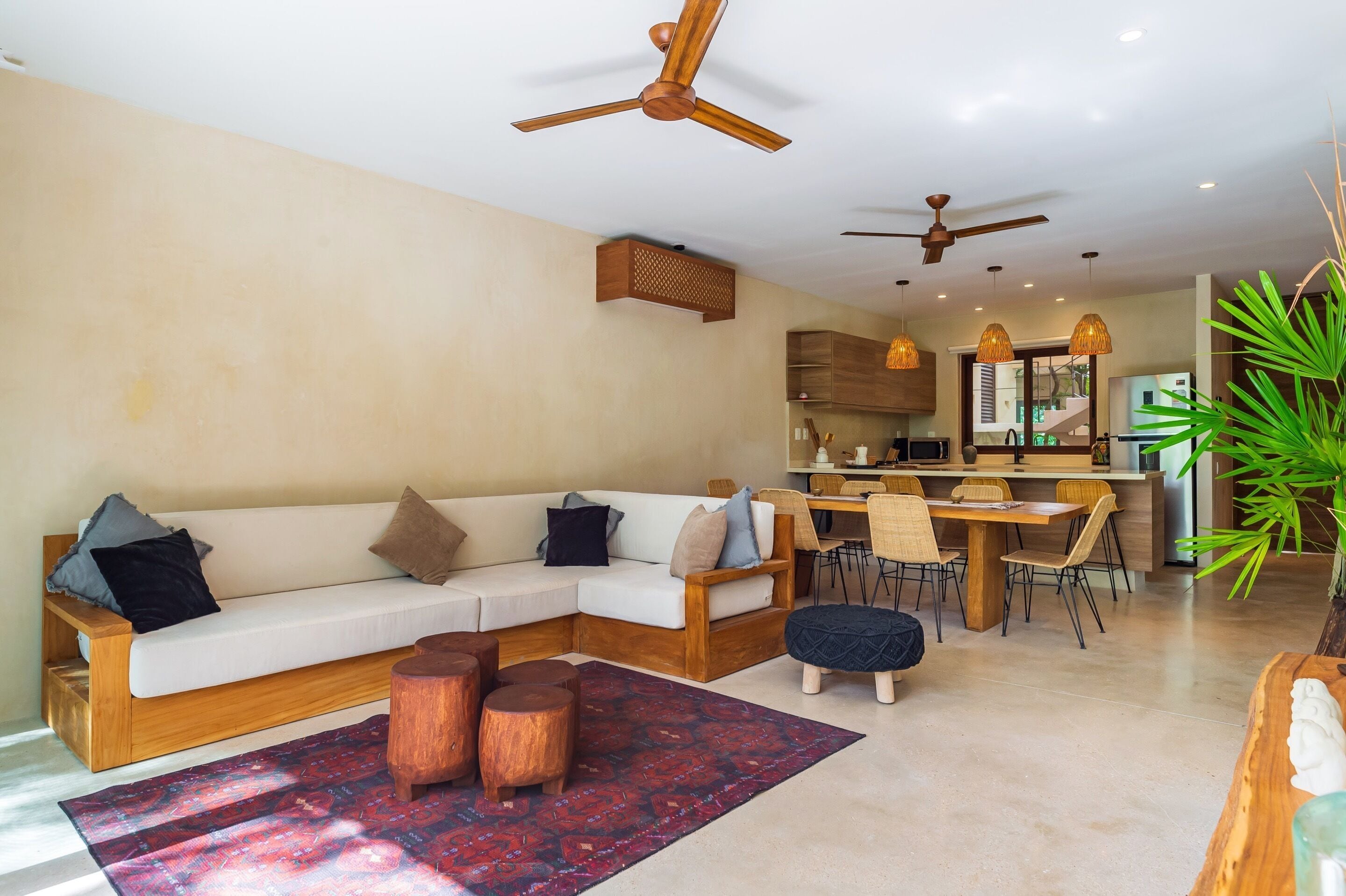 A modern living room with a sectional sofa, wooden coffee table, and ceiling fans.