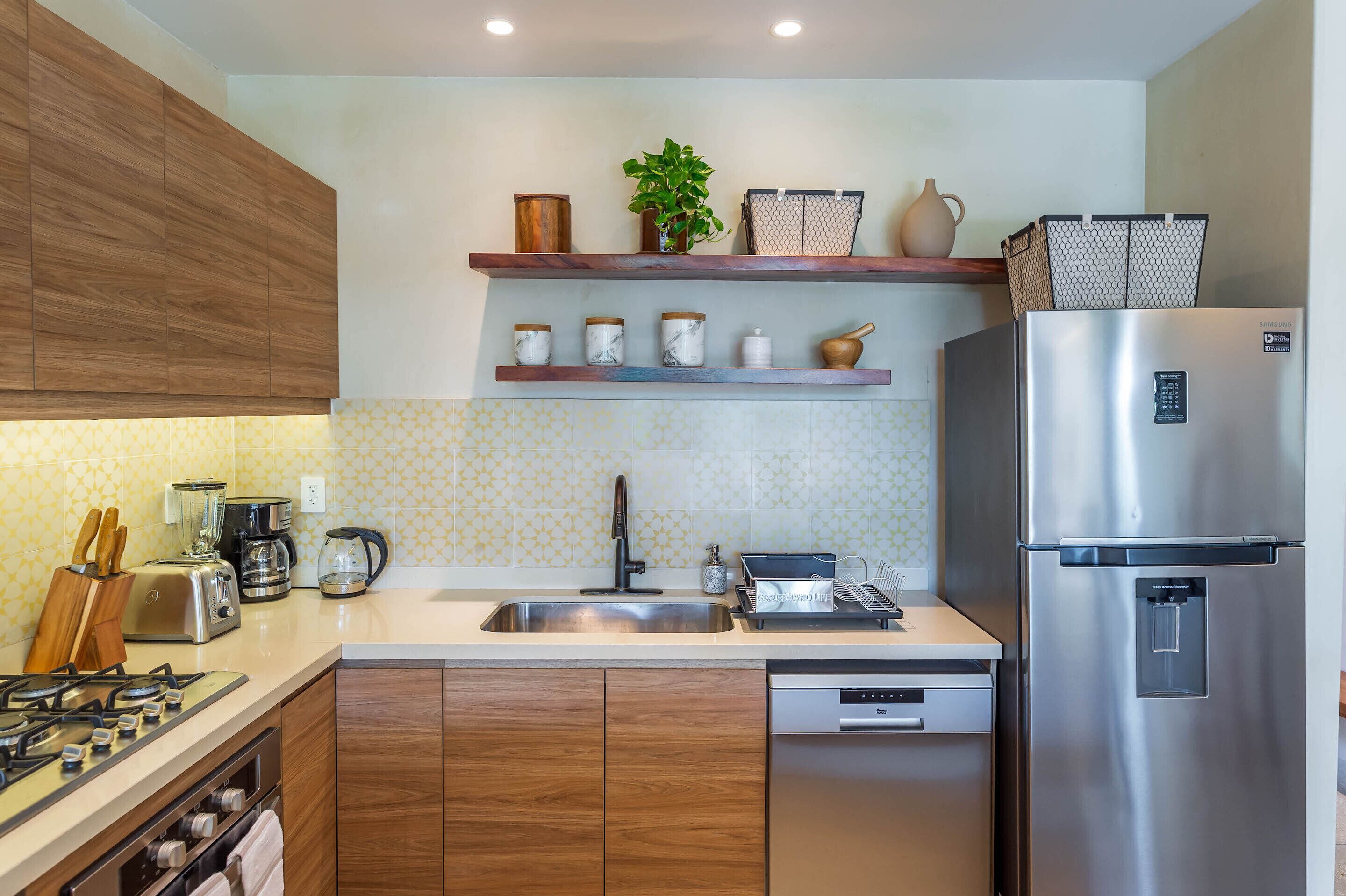 Una cocina moderna con armarios de madera, electrodomésticos de acero inoxidable y lavavajillas integrado.