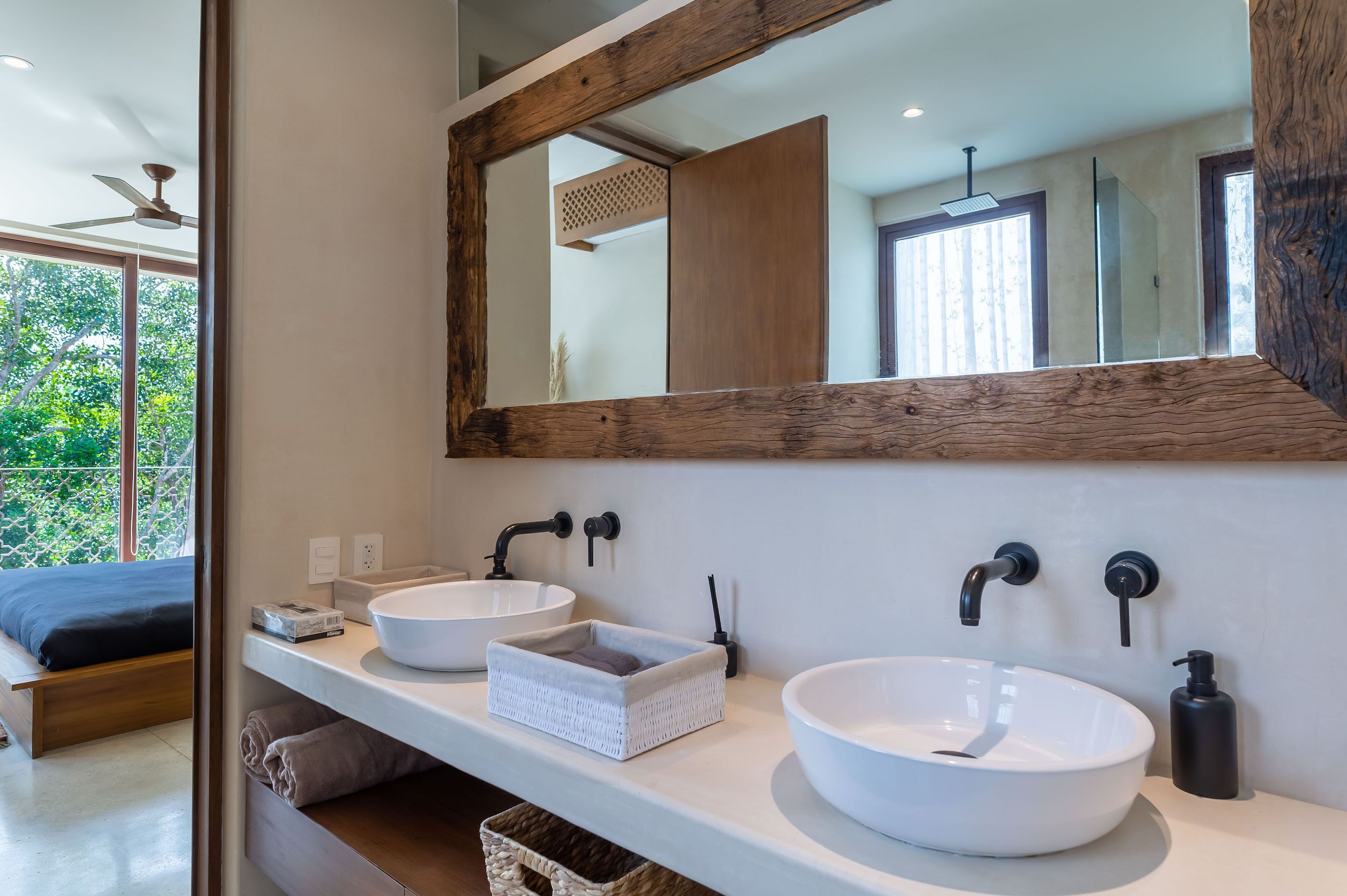 A modern bathroom with two white sinks, a large mirror, and a wooden ceiling.