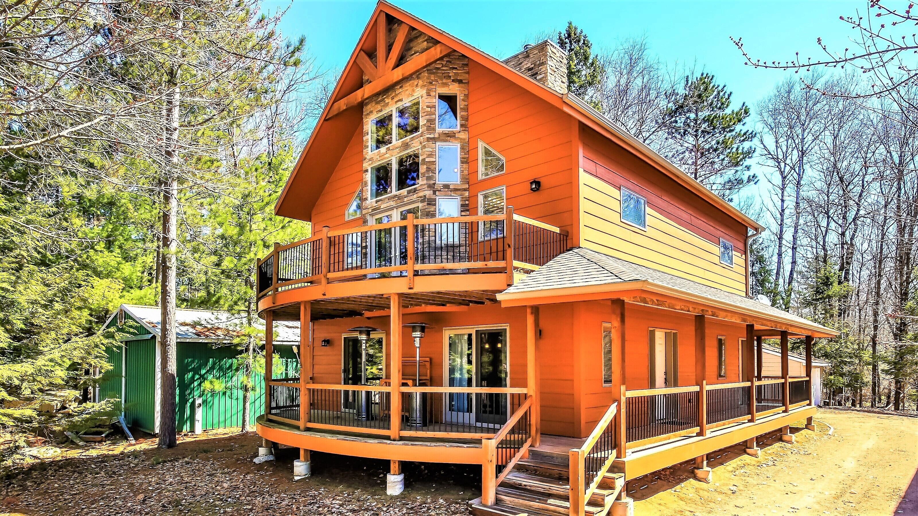 Eine zweistöckige Blockhütte mit Balkon und Veranda.