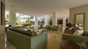 Eine großzügige Lobby mit moderner Sitzgelegenheit, hohen Säulen und Blick ins Freie.