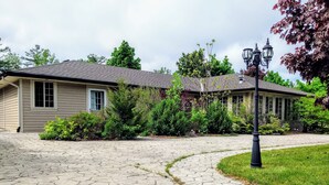 A residential property with a paved driveway leading to a house with a tiled roof. - Ipperwash bliss sleep 5 hear the waves ☀️🌊 (Lambton Shores)