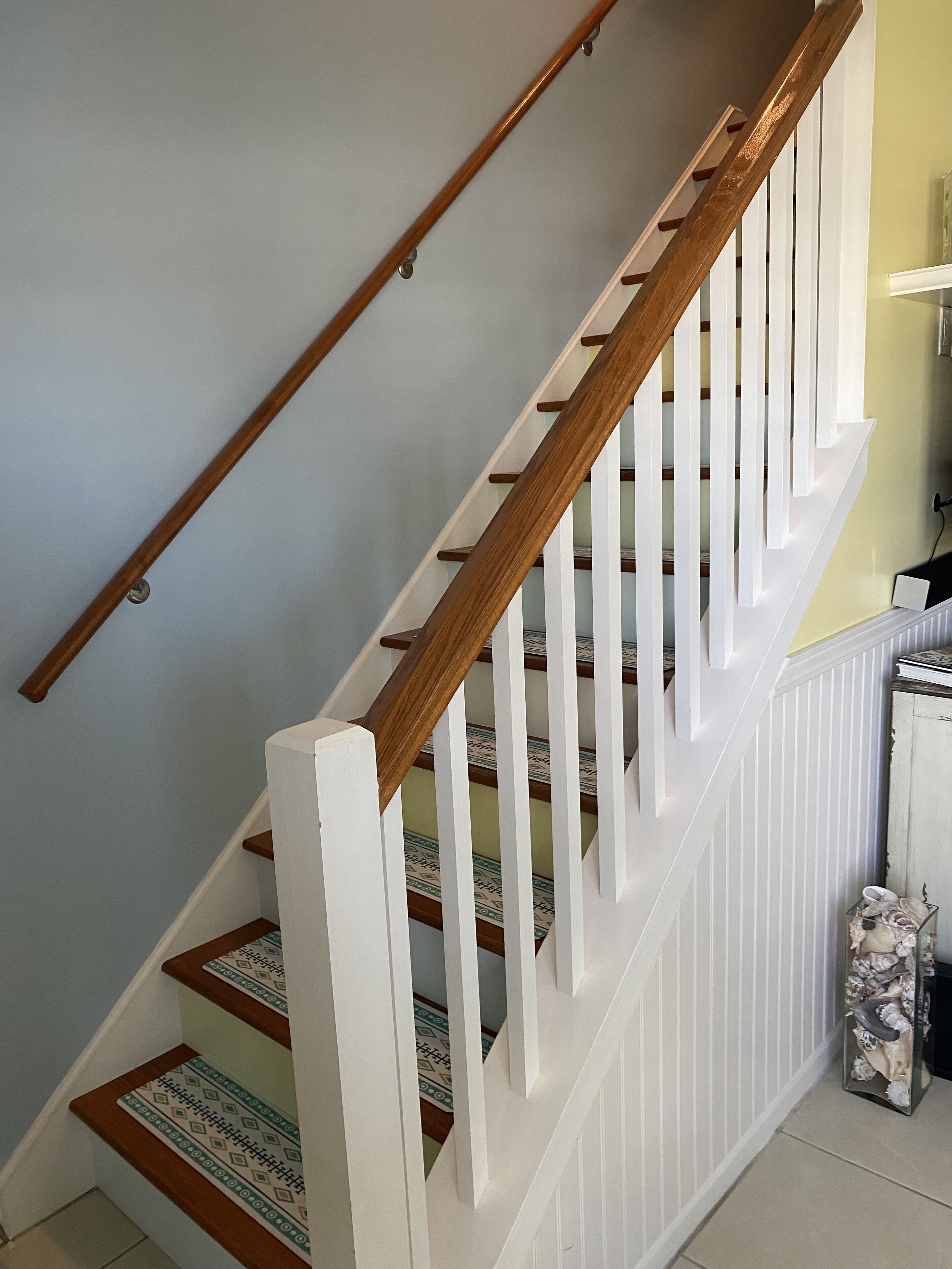 A staircase with wooden handrails and white balusters.