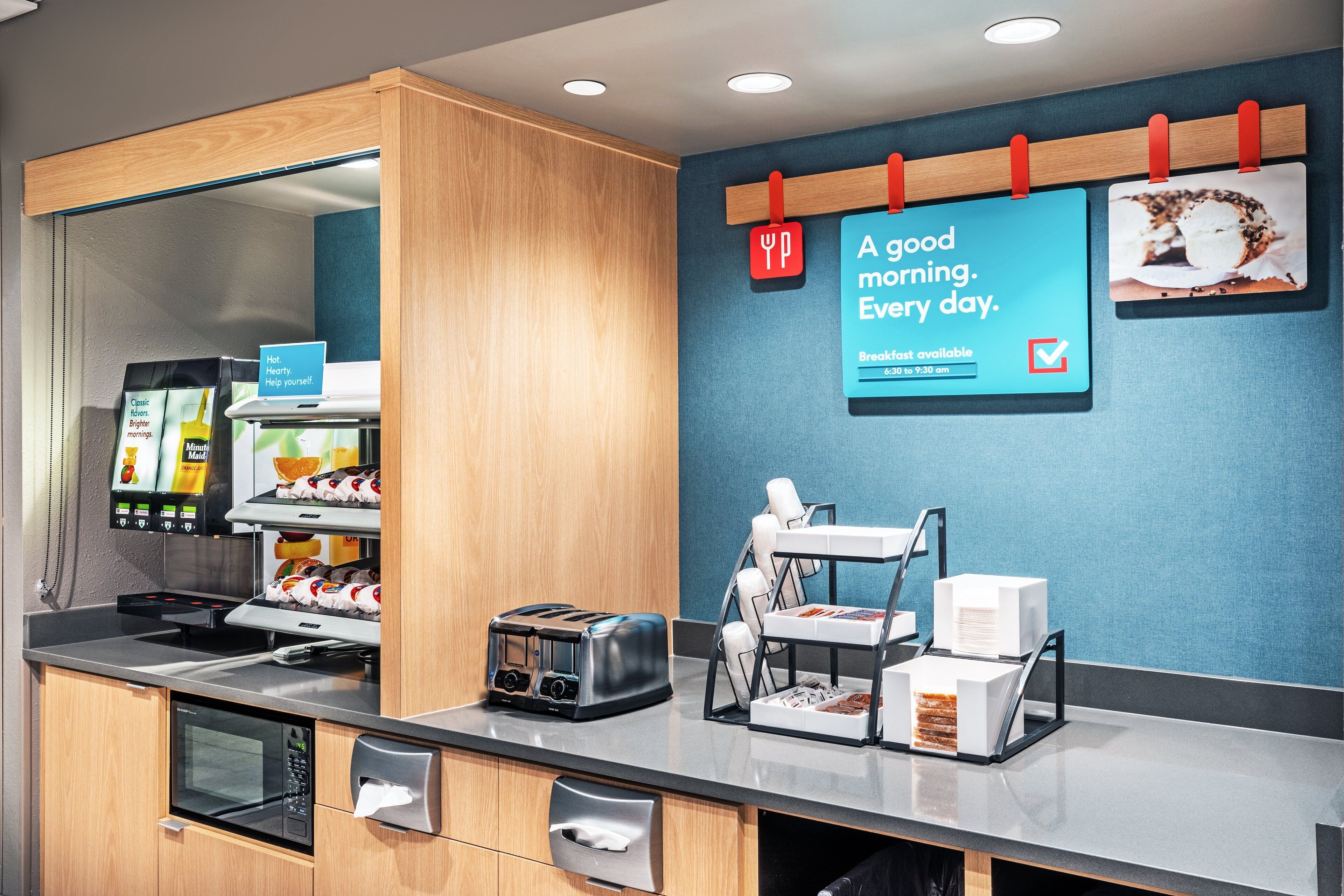 A breakfast area with a toaster, a coffee machine, and a sign that reads "A good morning. Every day."