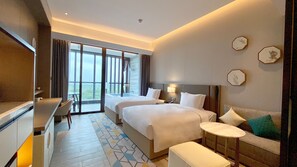 A hotel room with two beds, a desk, a sofa, and a balcony with a view. - Holiday Inn Resort Maoshan Hot-Spring by IHG (Zhenjiang)