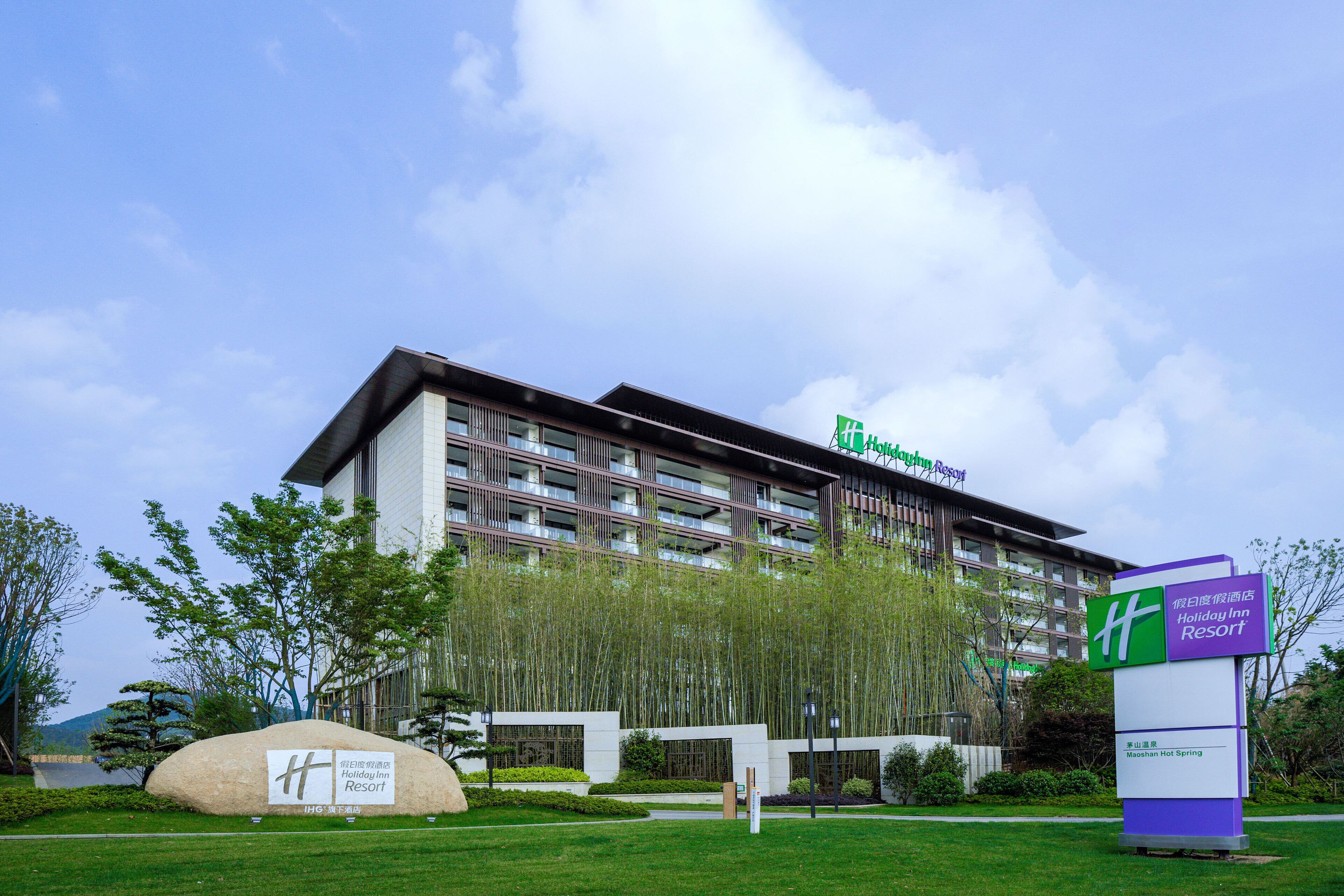 Ein Holiday Inn Resort mit moderner Architektur, ausgestattet mit einer großen Schautafel und einem gepflegten Rasenbereich.