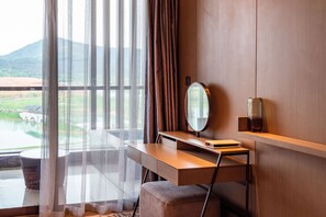 A room with a desk, a mirror, and a view of a bridge over a body of water. - Holiday Inn Resort Maoshan Hot-Spring by IHG (Zhenjiang)
