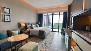 A hotel room with a bed, a sofa, a desk, a chair, a small table, and a TV. - Holiday Inn Resort Maoshan Hot-Spring by IHG (Zhenjiang)