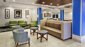 A lobby with seating, a reception desk, and artwork on the walls. - Holiday Inn Express & Suites Fayetteville by IHG (Fayetteville)