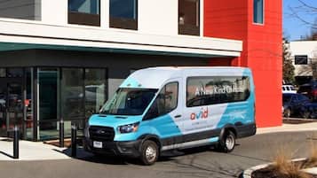 Un edificio moderno con una camioneta azul y blanca estacionada frente a él, con la leyenda 'A New Kind Of Hotel'.