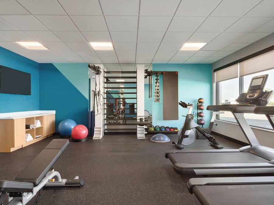 A gym with treadmills, exercise balls, and weights.