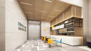 A modern reception area with a wooden ceiling, a counter with a menu, and seating with yellow and blue chairs. - Holiday Inn Express Nanchang Qingshan Lake View by IHG (Nanchang)